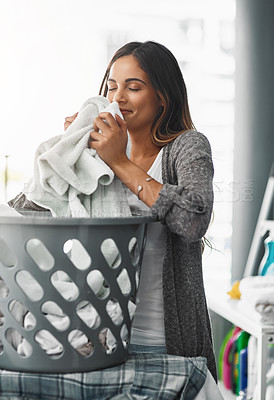 Buy stock photo Cropped shot of an attractive young woman doing her laundry at home