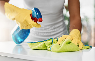 Buy stock photo Cropped shot of an unrecognizable young woman cleaning a table at home