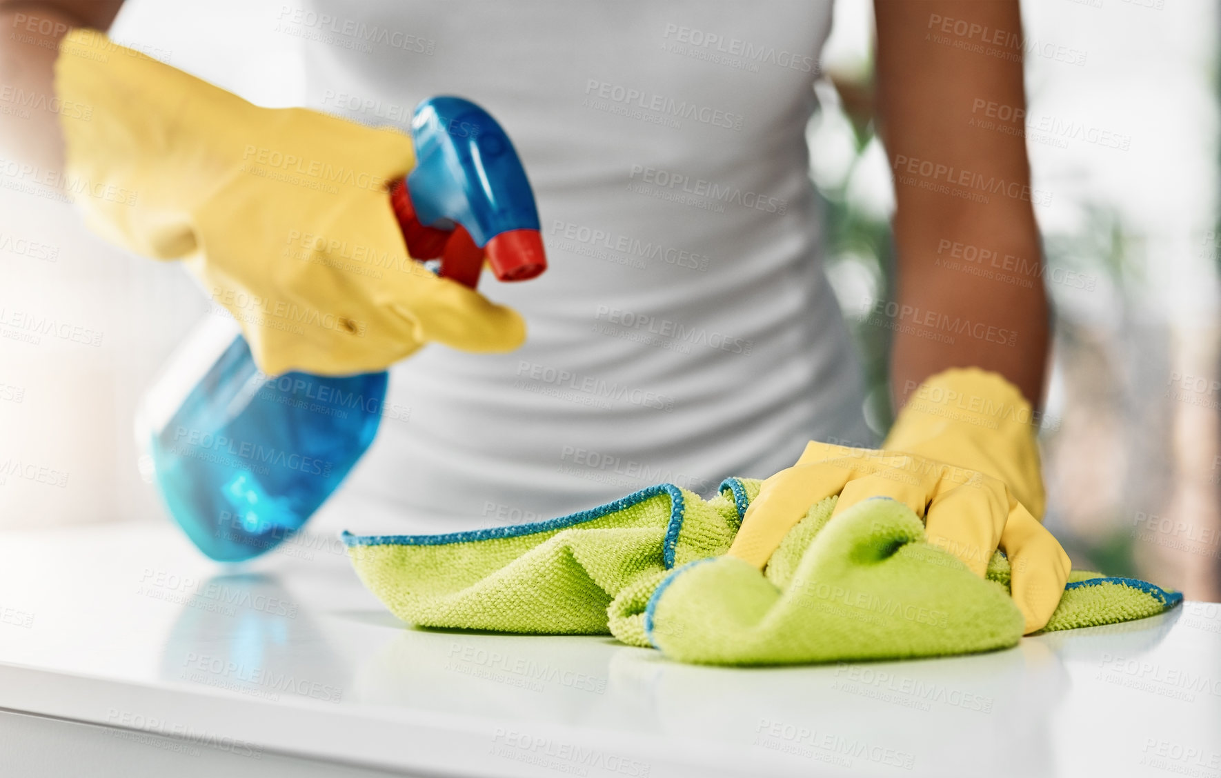 Buy stock photo Cropped shot of an unrecognizable young woman cleaning a table at home