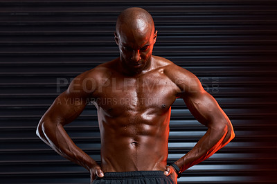 Buy stock photo Studio shot of an athletic young man posing with his hands on his hips against a grey background