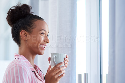 Buy stock photo Shot of an attractive young woman enjoying her morning coffee at home