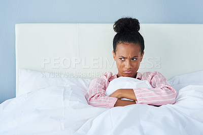 Buy stock photo Shot of an attractive young woman sulking in bed at home