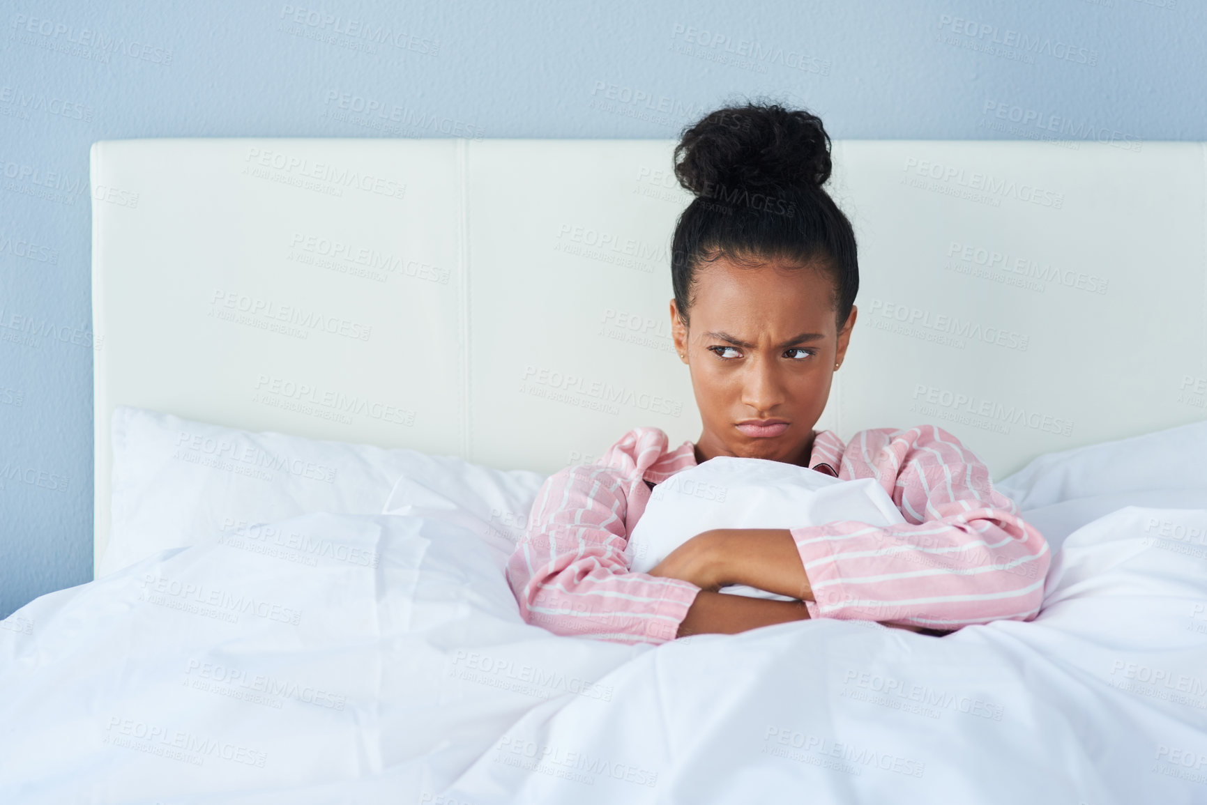Buy stock photo Shot of an attractive young woman sulking in bed at home