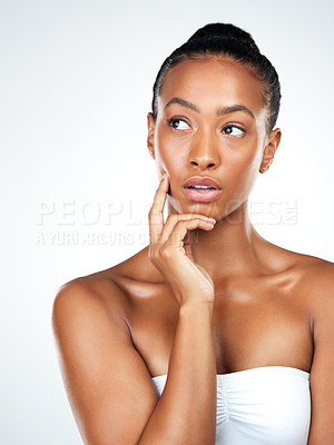 Buy stock photo Studio portrait of an attractive young woman posing and gently touching her neck while standing against a white background