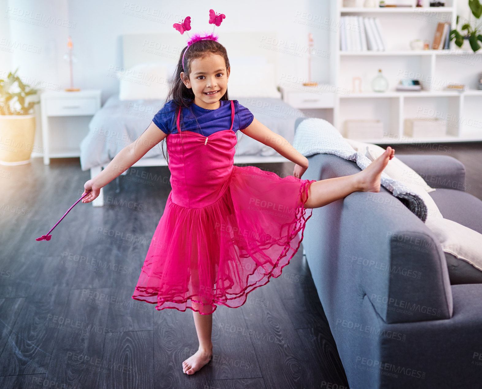 Buy stock photo Full length shot of an adorable little girl dressed up as a fairy showing off her ballet moves at home