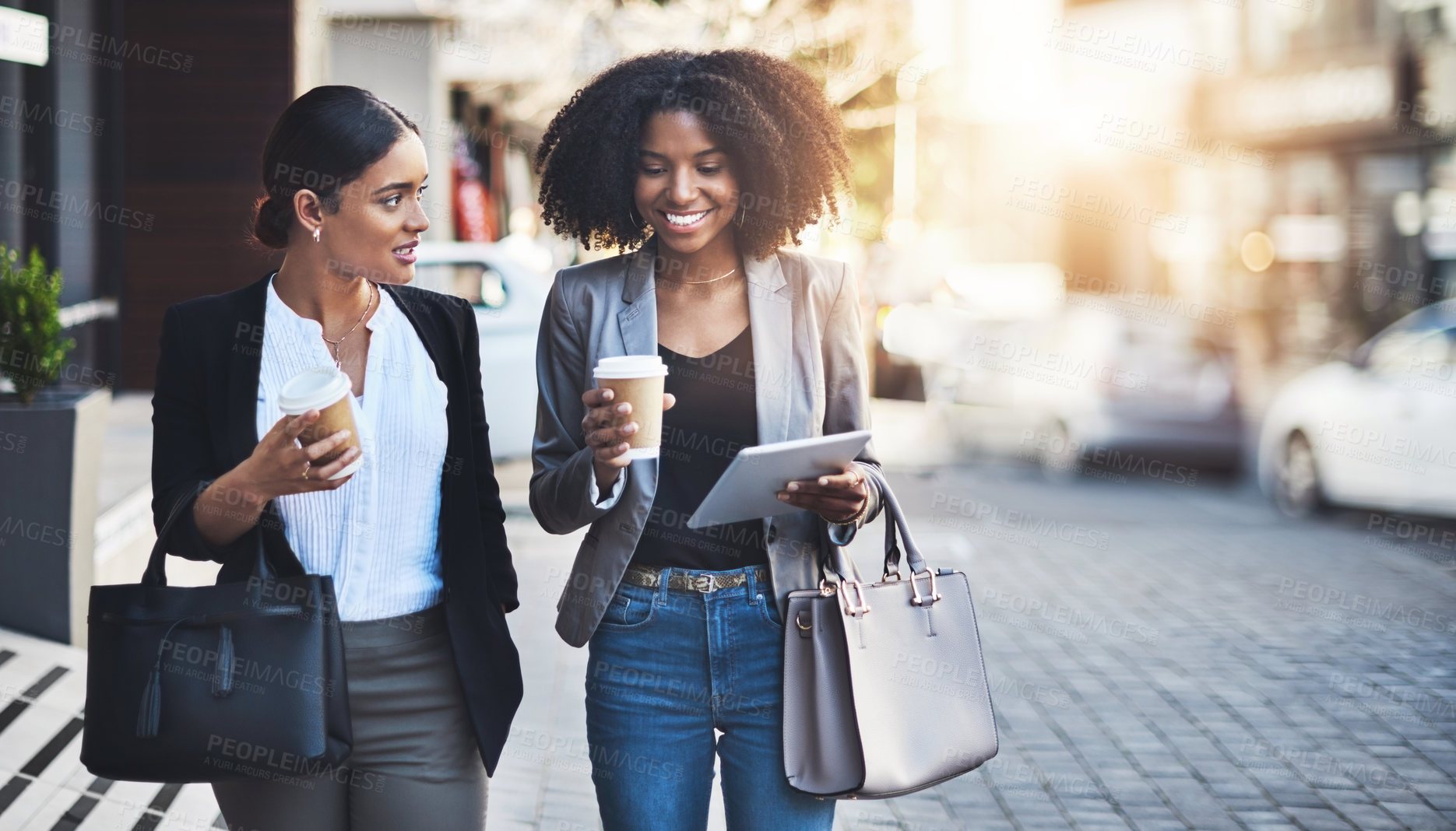 Buy stock photo Shot of two businesswomen having a discussion while walking in the city