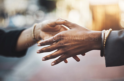 Buy stock photo Closeup shot of two businesswomen shaking hands in the city