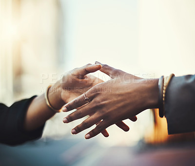 Buy stock photo Closeup shot of two businesswomen shaking hands in the city