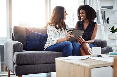 Buy stock photo Shot of two young businesswomen using a digital tablet and credit card in an office