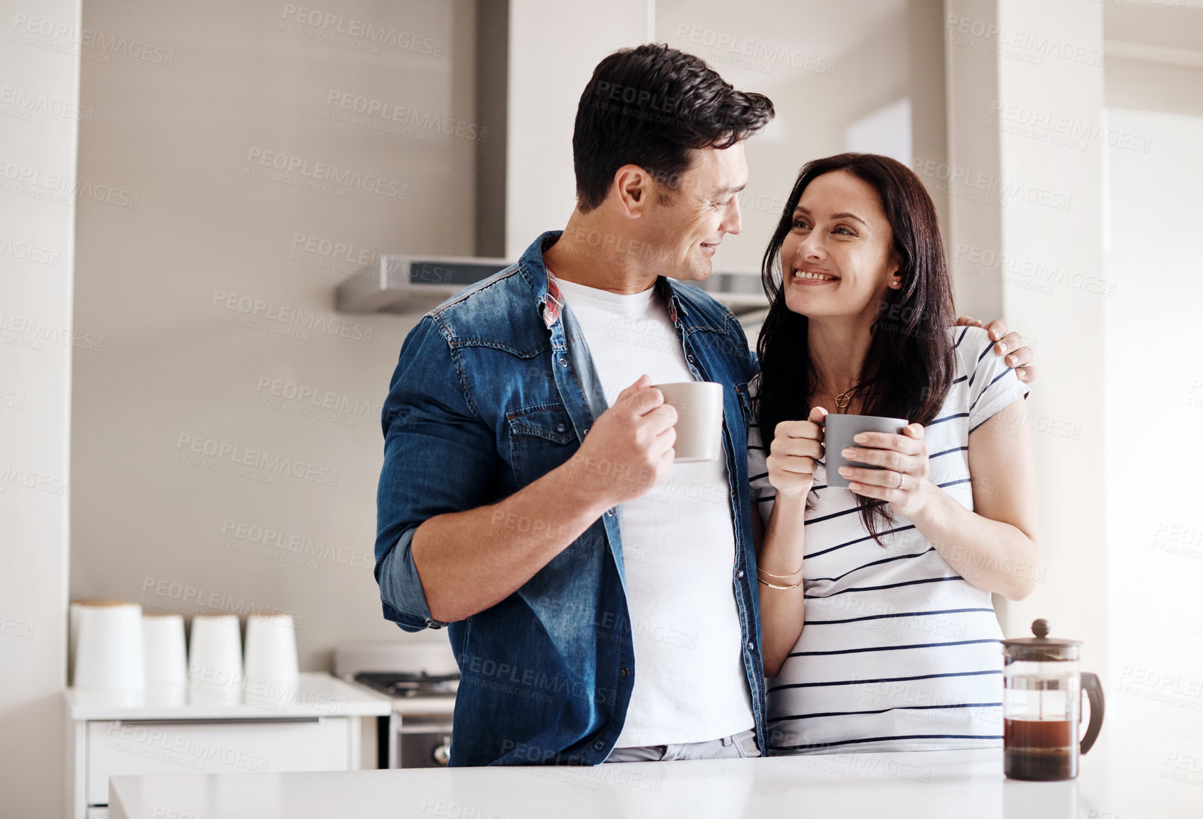 Buy stock photo Shot of a happy young couple having coffee together at home