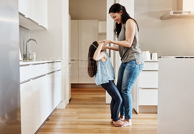 Buy stock photo Shot of an adorable little girl dancing with her mother at home