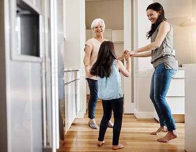 Buy stock photo Shot of an adorable little girl dancing with her mother and granny at home