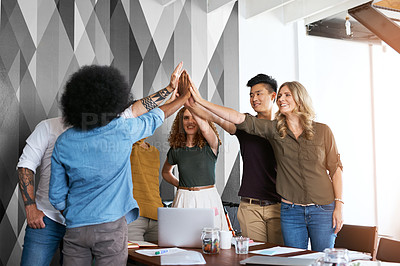 Buy stock photo Cropped shot of a group of designers high fiving during having a meeting in an office