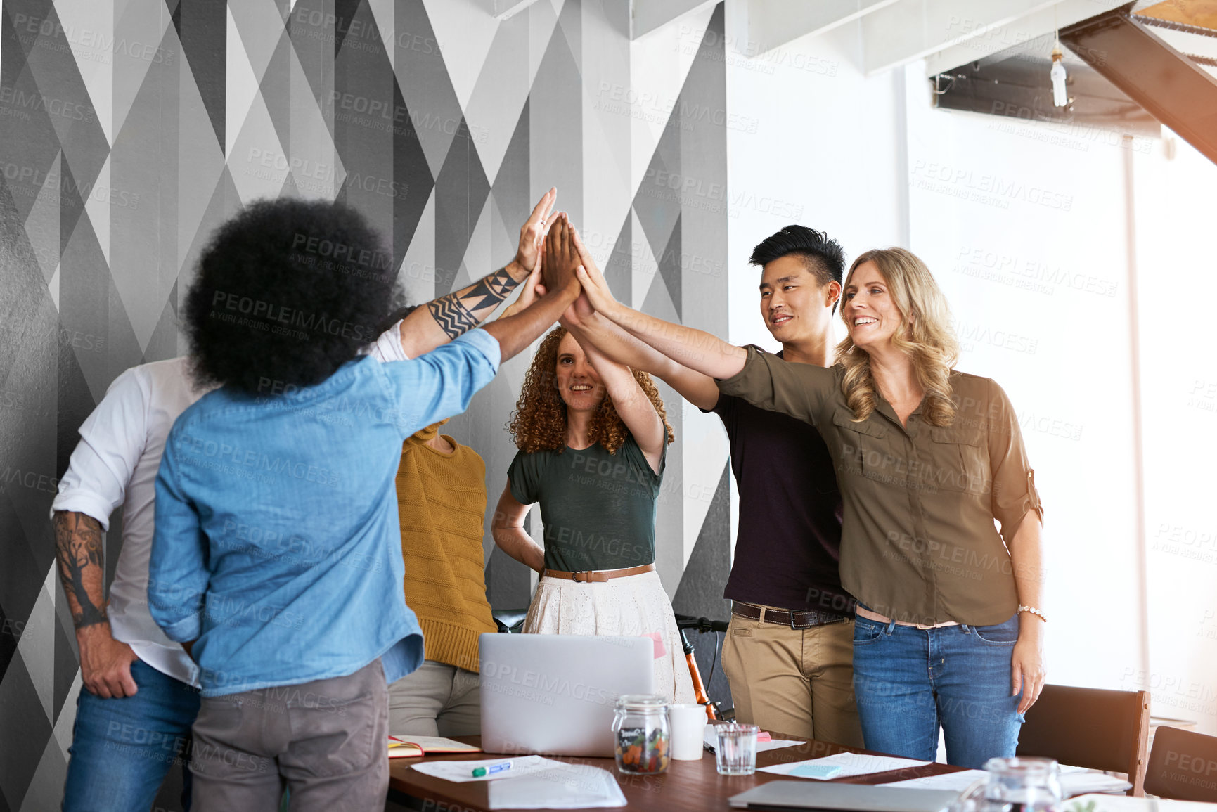 Buy stock photo Cropped shot of a group of designers high fiving during having a meeting in an office