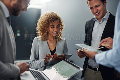Buy stock photo Cropped shot of a group of businesspeople using digital devices while brainstorming in an office