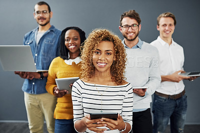 Buy stock photo Studio portrait of a group of businesspeople using wireless technology together while standing in line against a gray background