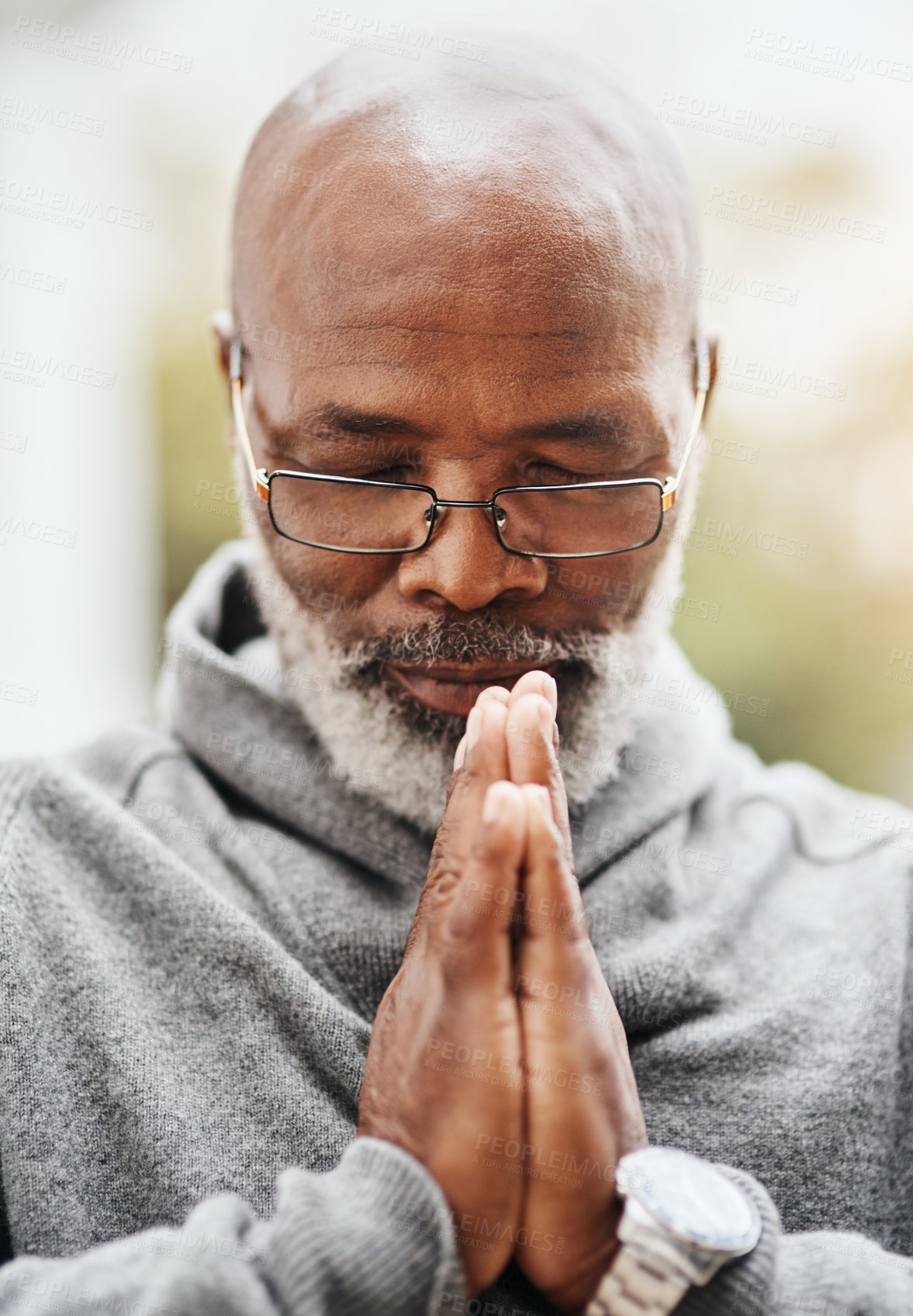 Buy stock photo Shot of a senior man holding his hands together in prayer while sitting in his wheelchair outside
