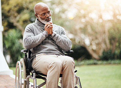 Buy stock photo Shot of a senior man holding his hands together while sitting in his wheelchair outside