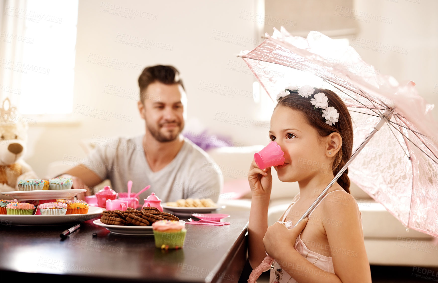 Buy stock photo Shot of a father and his little daughter having a tea party together at home