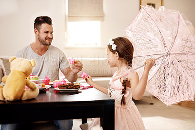Buy stock photo Shot of a father and his little daughter having a tea party together at home