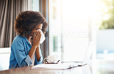 Buy stock photo Portrait of a young woman blowing her nose with a tissue while working at home