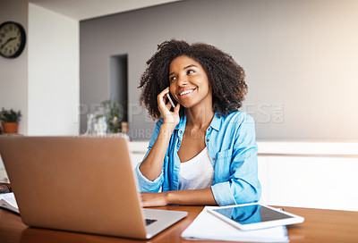 Buy stock photo Shot of an attractive young woman taking a phone call while working on her laptop at home