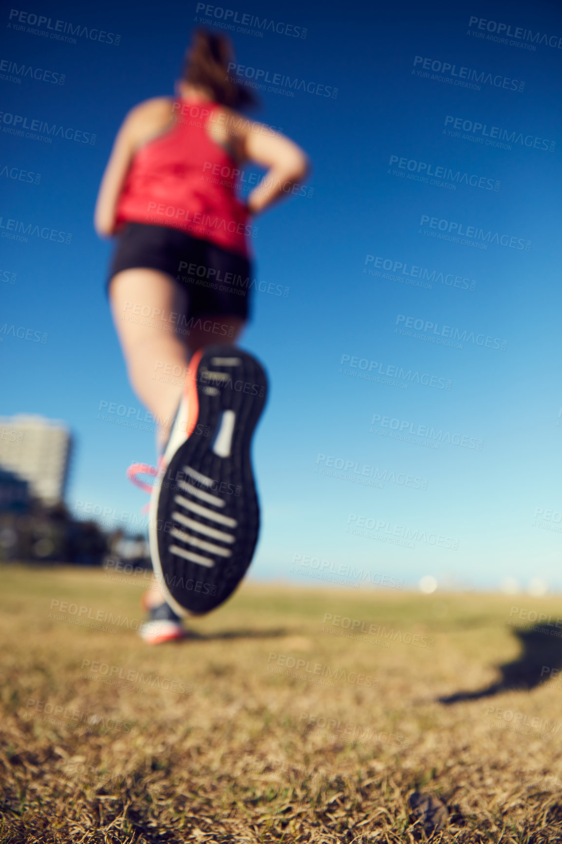 Buy stock photo Rearview shot of a sporty young woman exercising outdoors