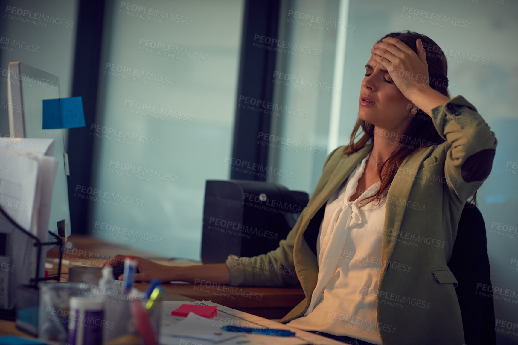 Buy stock photo Shot of a young businesswoman looking stressed while working late at the office