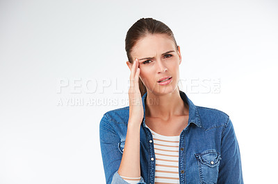 Buy stock photo Studio portrait of a young woman suffering from a headache against a grey background