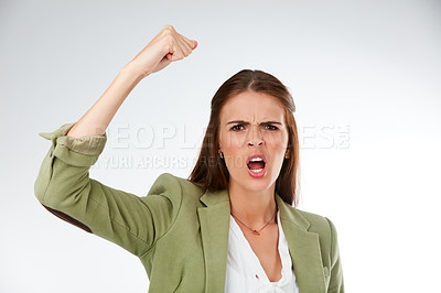 Buy stock photo Studio portrait of a young woman shaking her fist in anger against a grey background