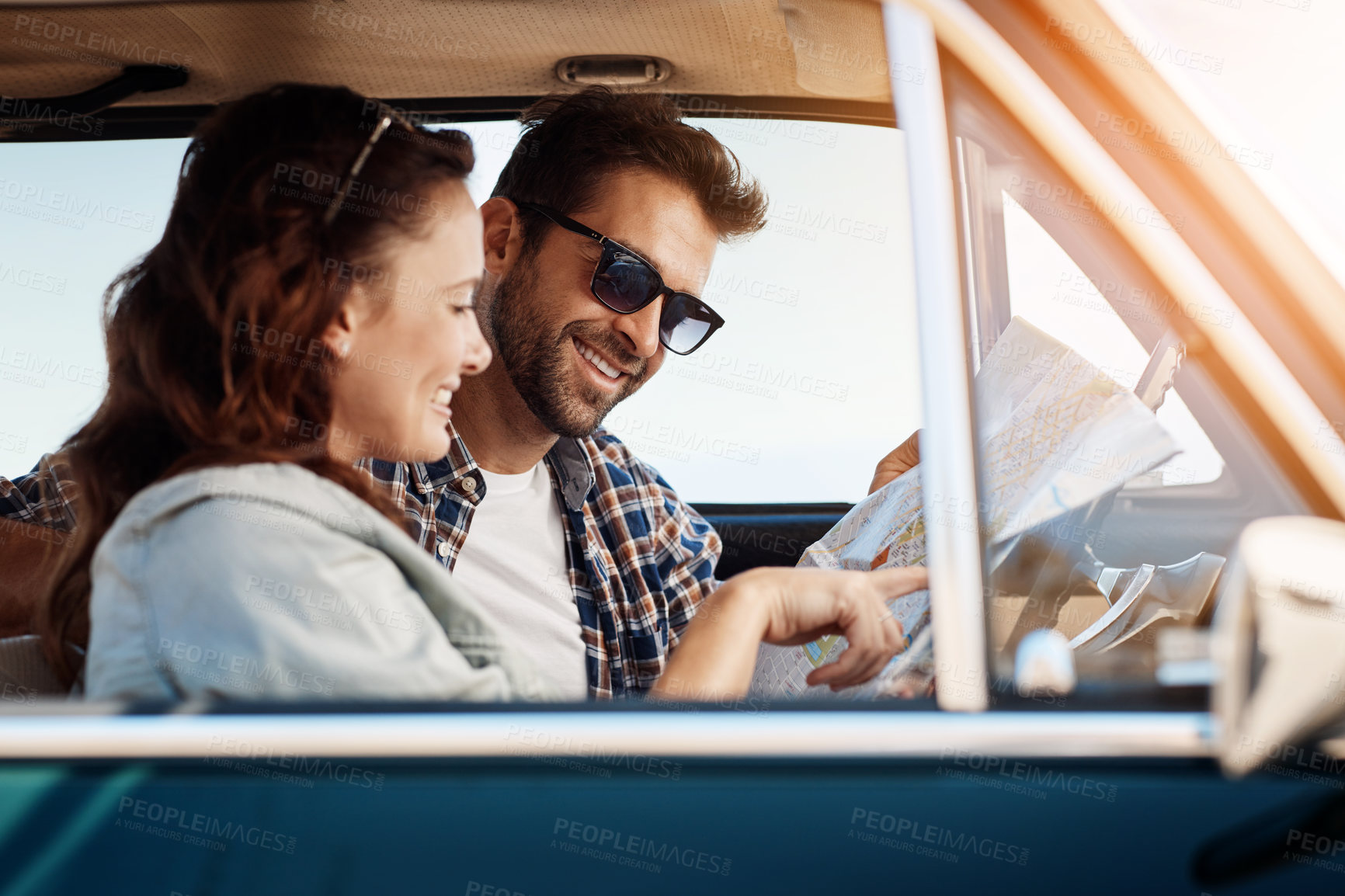 Buy stock photo Cropped shot of an affectionate couple checking a map while enjoying a road trip