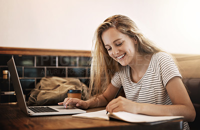Buy stock photo Cropped shot of a focussed young student using her laptop to study at a table in a cafe