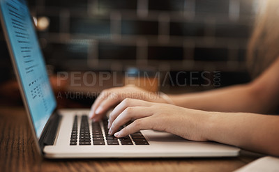 Buy stock photo Cropped shot of an unrecognizable young student using her laptop to study at a tablet in a cafe