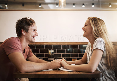 Buy stock photo Cropped shot of a happy young student couple holding hands while studying together at a cafe