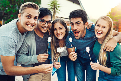 Buy stock photo Portrait of a group of young friends posing together and holding up marshmallows on sticks outside