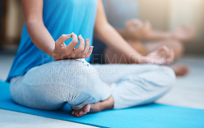 Buy stock photo Shot of an unrecognizable woman meditating on her yoga mat with her husband in the background
