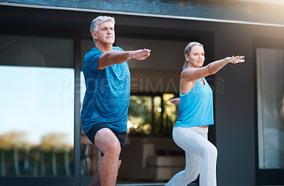 Buy stock photo Shot of a mature and happy couple doing yoga exercise outside of their home