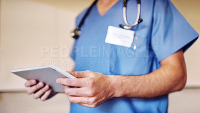 Buy stock photo Shot of an unrecognizable doctor using his tablet in his office