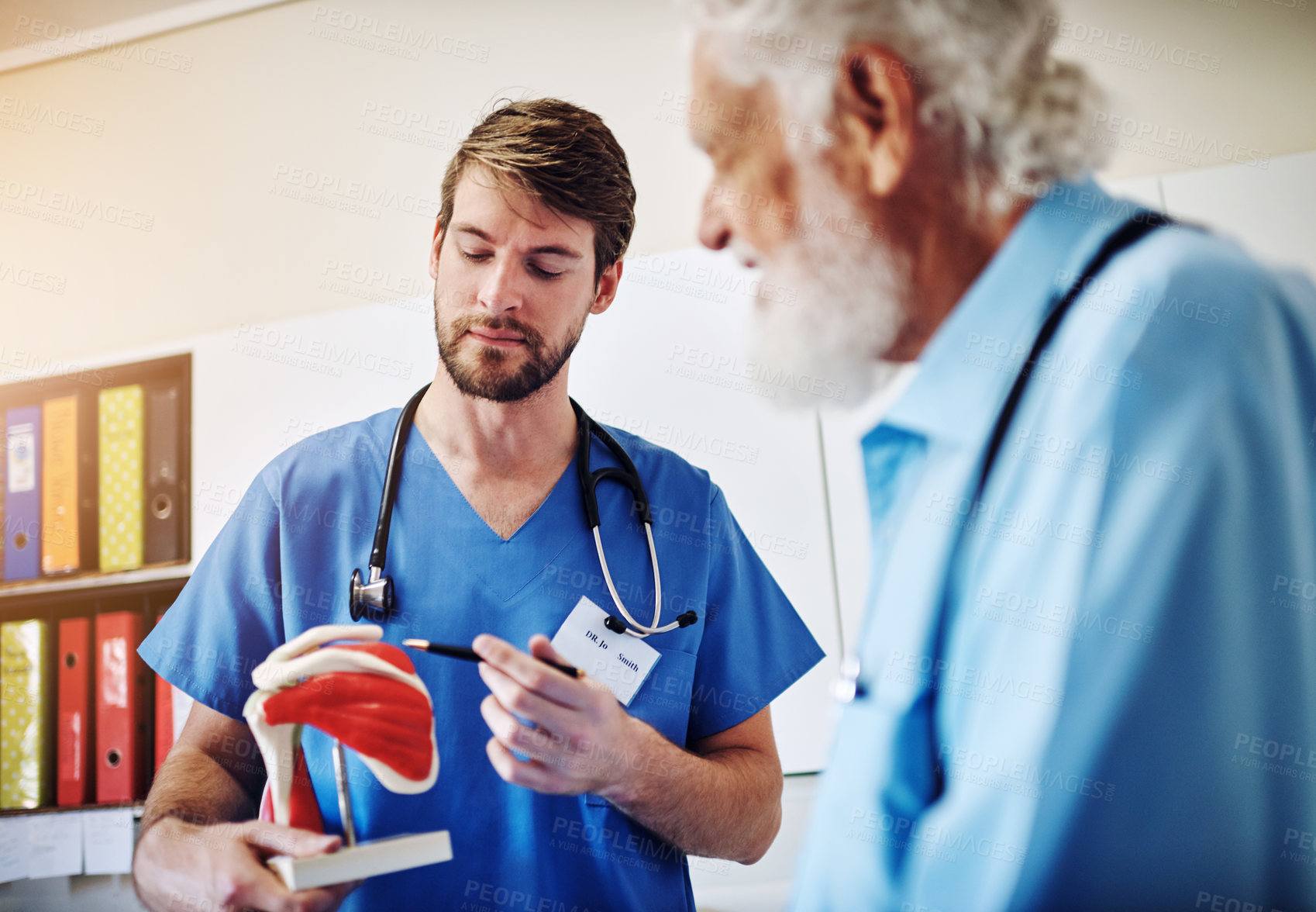 Buy stock photo Anatomy, model and doctor with senior patient for demonstration for surgery, diagnosis and consulting. Healthcare, hospital and person with man for treatment, joint recovery and medical service