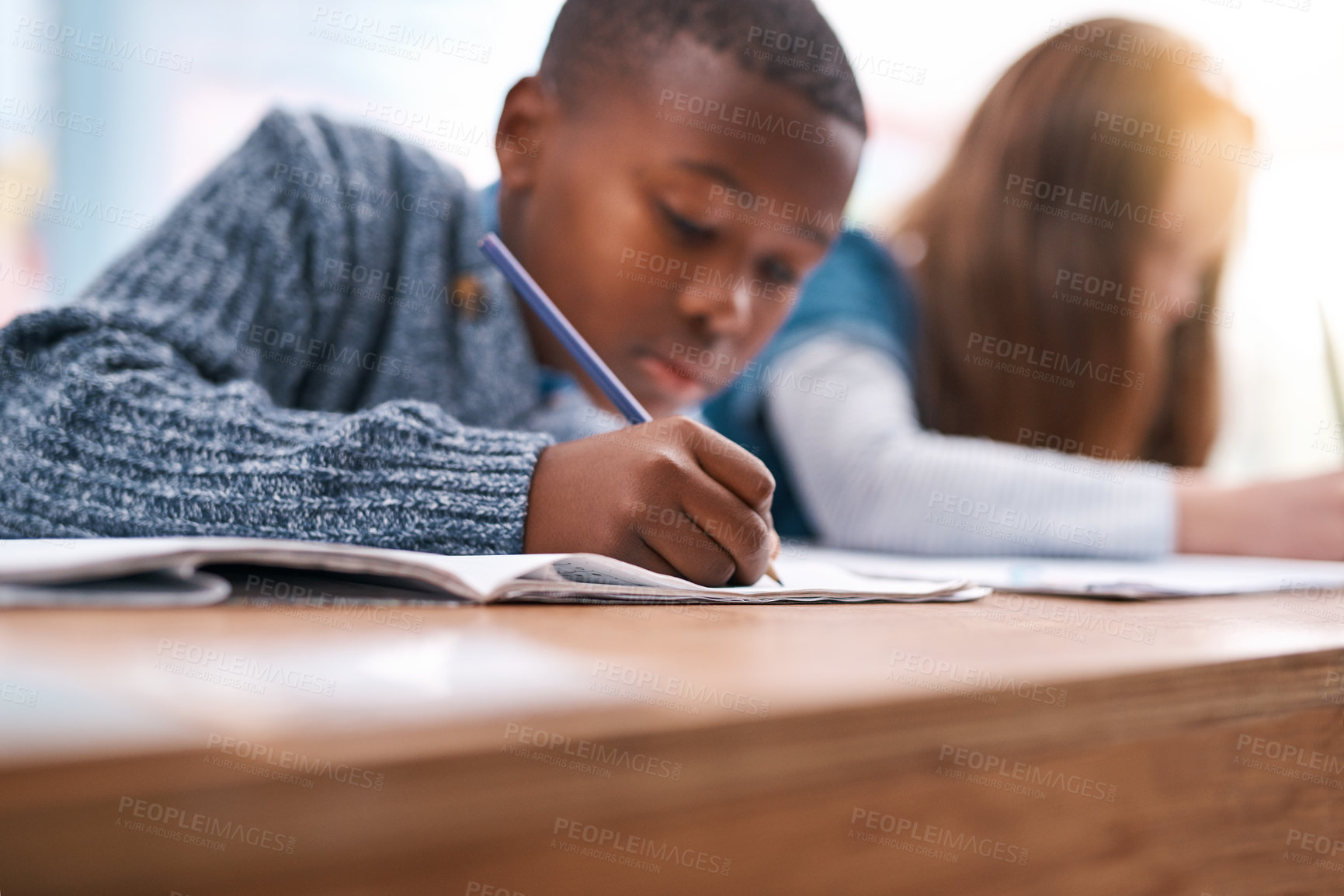 Buy stock photo Cropped shot of two elementary school kids doing school work inside of the class during the day