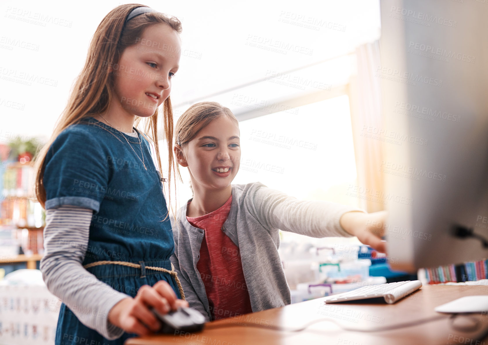 Buy stock photo Cropped shot of two elementary school children browsing on a computer inside of the class during the day