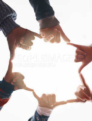 Buy stock photo Low angle shot of a group of cheerful elementary school kids forming a huddle with their hands and showing a hand sign