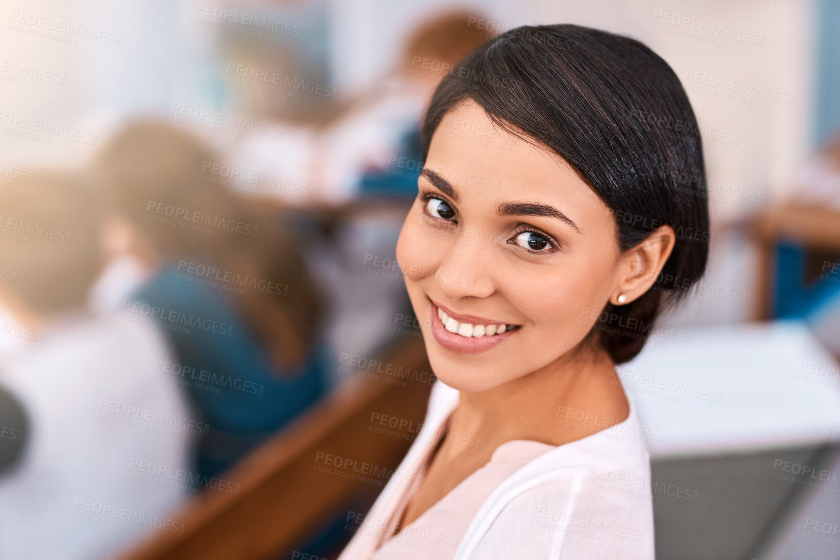 Buy stock photo Shot of a cheerful young female teacher giving class to her students inside a school during the day
