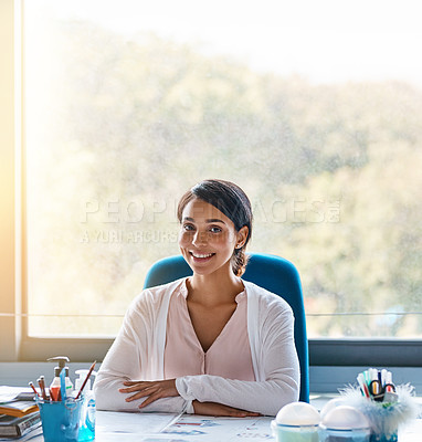 Buy stock photo Portrait shot of a focussed young female teacher marking papers inside of her classroom during the day
