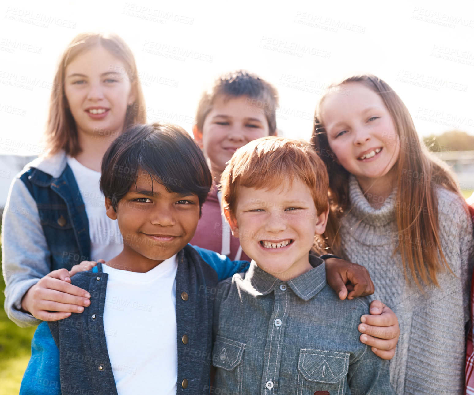 Buy stock photo Portrait of a group of cheerful elementary school kids standing next to each other while looking at the camera