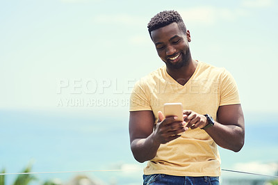 Buy stock photo Black man, phone and typing on social media, app or text and message, communication and mockup blue sky background. Smartphone, online networking or internet conversation on screen with smile