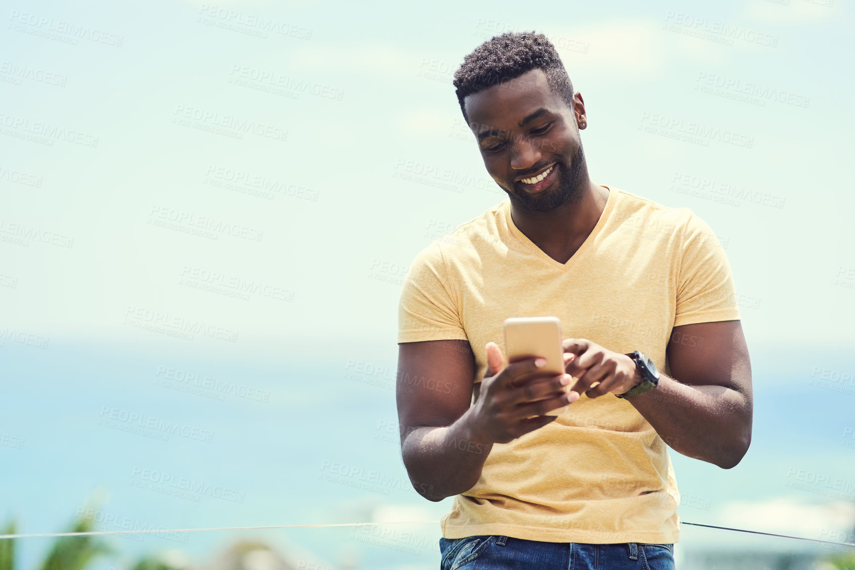 Buy stock photo Black man, phone and typing on social media, app or text and message, communication and mockup blue sky background. Smartphone, online networking or internet conversation on screen with smile