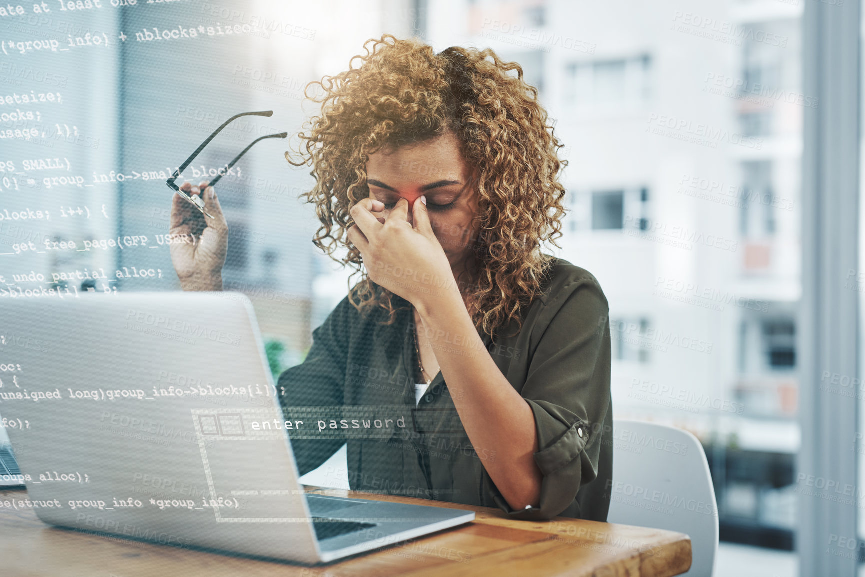 Buy stock photo Shot of a young businesswoman suffering from a headache while using her laptop at work