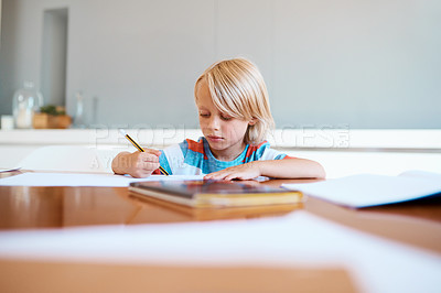 Buy stock photo Shot of an adorable little boy doing his homework at home