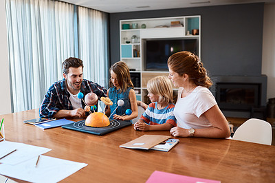 Buy stock photo Shot of a beautiful young family working together on a science project at home
